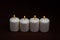 Four whiteÂ candlesÂ flameÂ burningÂ onÂ dark backgroundÂ withÂ copyÂ space forÂ text